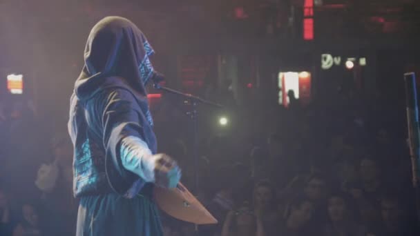 SAINT PETERSBURG, RUSSIE - 26 JUIN 2015 : Chanteuse en manteau avec des mains balalaika sur scène dans une boîte de nuit bondée. Pleins feux. Concert live — Video