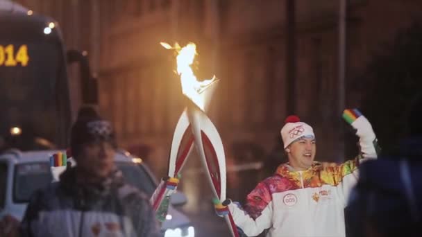 Petrohrad, Rusko - 27 října 2013: štafeta olympijského ohně v Petrohradu v říjnu. Nosiči předat plamen. Dobrý večer. Vlna ruka — Stock video