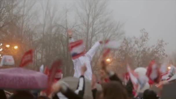 SAN PETERSBURG, RUSIA - 27 DE OCTUBRE DE 2013: Mucha gente ondea banderitas rojas, globos aéreos en la carretera. Chica en las manos chaqueta blanca ola. Evento . — Vídeo de stock