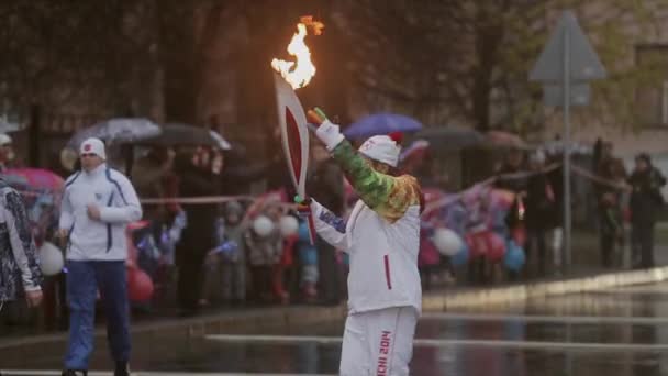 SAINT PETERSBURG, RUSSIA - OCTOBER 27, 2013: Relay race Olympic flame in Saint Petersburg. Bari Alibasov run with flame, wave hand. Evening — Stock Video