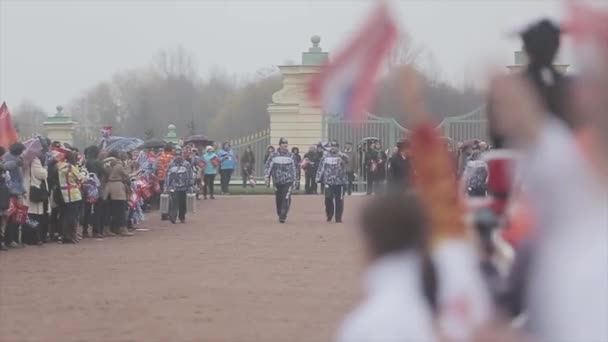 奥运圣火在圣彼得堡，俄罗斯圣彼得堡-2013 年 10 月 27 日 ︰ 接力赛跑。穿制服的男人守住蜡烛的舞台。人们挥舞旗帜 — 图库视频影像