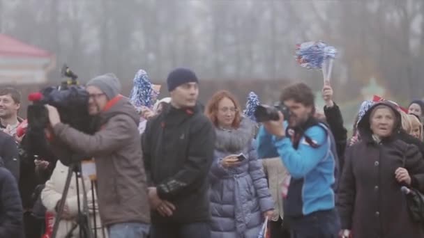 Saint petersburg, russland - 27. oktober 2013: viele menschen schwenken blaue pom pom auf der straße. Zwei Kameramänner. Veranstaltung. Publikum. Herbstabend im Park — Stockvideo