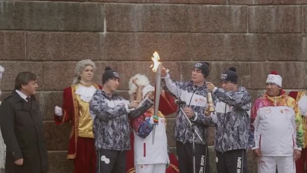 Sint-Petersburg, Rusland - 27 oktober 2013: estafette Olympische vlam in Sint-Petersburg. Mannen in uniform verlichting vlam aan fakkeldrager. Applaus — Stockvideo