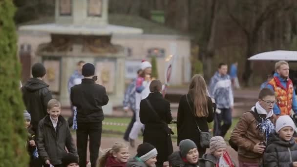 SAN PETERSBURG, RUSIA - 27 DE OCTUBRE DE 2013: Carrera de relevos Llama olímpica en Peterhof, San Petersburgo. Mujer portador de la antorcha correr con llama en el parque — Vídeos de Stock