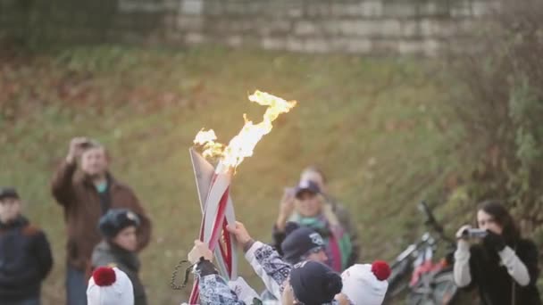 SAN PETERSBURGO, RUSSIA - 27 OTTOBRE 2013: Corsa a staffetta Fiamma olimpica a San Pietroburgo. Il portatore di torce maschio passa la fiamma alla ragazza. Poliziotto. Persone — Video Stock