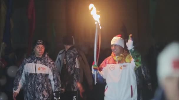 SAN PETERSBURG, RUSIA - 27 DE OCTUBRE DE 2013: Carrera de relevos Llama olímpica en San Petersburgo. El portador de la antorcha camina con mano de onda de llama. Guardias. Buenas noches. — Vídeos de Stock