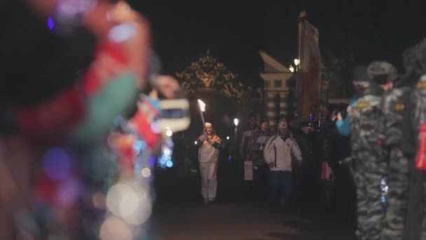 SAINT PETERSBURG, RUSSIA - OCTOBER 27, 2013: Relay race Olympic flame in Saint Petersburg. Torchbearer run with flame. People wave hands. Evening — Stock Video