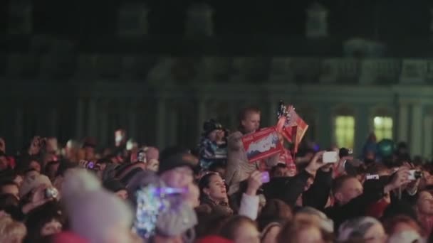 SAN PETERSBURG, RUSIA - 27 DE OCTUBRE DE 2013: Muchos adolescentes, adultos, niños se quedan en la calle, filman en cámara. Banderas rojas. Noche oscura. Multitud. — Vídeos de Stock
