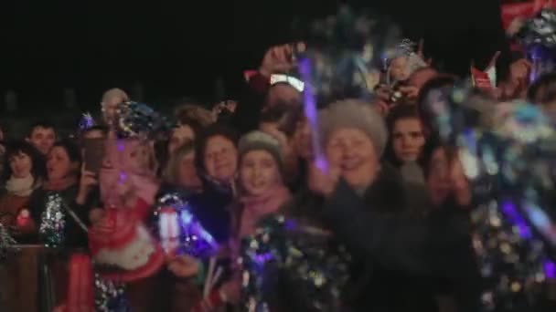 Saint petersburg, russland - 27. oktober 2013: viele erwachsene, kinder bleiben auf der straße, schütteln beleuchtete pom pom. Veranstaltung. Publikum. Dunkler Abend. Menschenmenge — Stockvideo