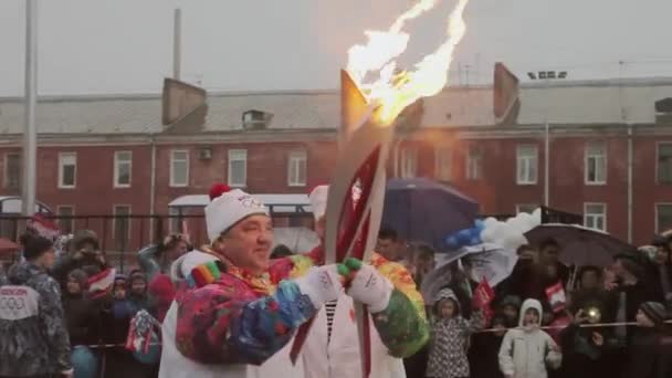 Sankt Petersburg, Ryssland-oktober 27, 2013: relä Race olympisk flamma i Sankt Petersburg. Bari Alibasov passera flamma till fackelbärare. Människor. Regn — Stockvideo