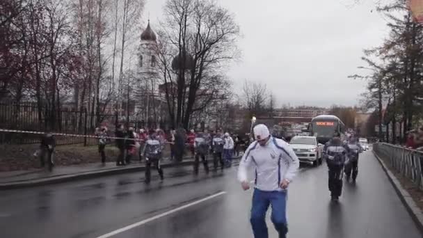 SAINT PETERSBURG, RUSSIA - OCTOBER 27, 2013: Relæ race olympisk flamme i Sankt Petersborg. En kvindelig fakkelbærer løber med flamme. Cortege. Bus – Stock-video