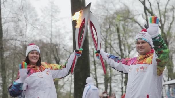 SAN PETERSBURG, RUSIA - 27 DE OCTUBRE DE 2013: Carrera de relevos Llama olímpica en San Petersburgo. Los portadores de antorchas pasan a la llama. Otoño. Sonríe. Dame cinco. — Vídeo de stock