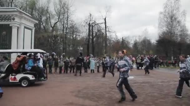 SAINT PETERSBURG, RÚSSIA - 27 de outubro de 2013: Corrida de revezamento Chama olímpica em Peterhof, São Petersburgo. Torchbearer fêmea correr com chama no parque . — Vídeo de Stock