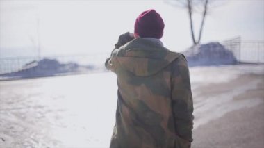 Adamın arka yüzüne, Güneş'ten kapakları yüz ile anıt için yürümek. Kış güneşli gün. Soğuk tonları