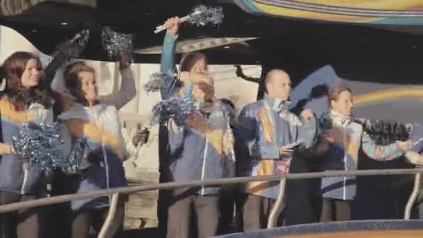 SAN PETERSBURG, RUSIA - 27 DE OCTUBRE DE 2013: Carrera de relevos de llama olímpica en San Petersburgo. Los partidarios saludan pom pom desde el autobús. Uniforme. Soleado. — Vídeo de stock