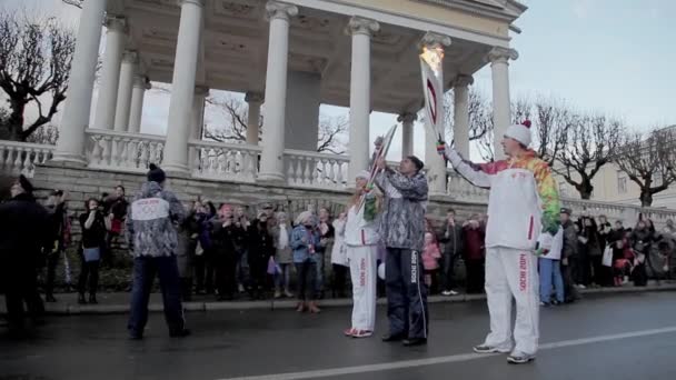 SAN PETERSBURGO, RUSSIA - 27 OTTOBRE 2013: Corsa a staffetta Fiamma olimpica a San Pietroburgo. Il portatore di torce donna riceve fiamma dall'uomo. Autunno . — Video Stock