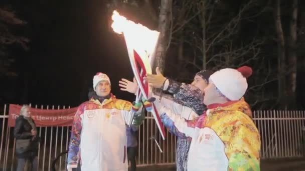 俄罗斯圣彼得堡 - 2013年10月27日：接力赛奥运圣火在圣彼得堡举行。火炬手将圣火传递给人类。均匀。漆黑的夜晚 — 图库视频影像