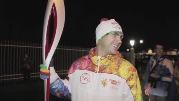 SAN PETERSBURG, RUSIA - 27 DE OCTUBRE DE 2013: Carrera de relevos Llama olímpica en San Petersburgo. Feliz mano portador de la antorcha. Uniforme. Noche oscura — Vídeo de stock