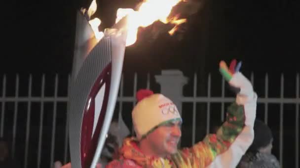 SAN PETERSBURG, RUSIA - 27 DE OCTUBRE DE 2013: Carrera de relevos Llama olímpica en San Petersburgo. El portador de la antorcha recibe la llama de la mujer. Noche oscura . — Vídeos de Stock