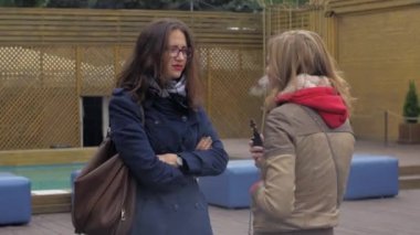 Saint Petersburg, Rusya Federasyonu - 28 Mayıs 2016: İki kız sokakta elektronik sigara içmek. Vaper. Buhar çok. Sigara içen