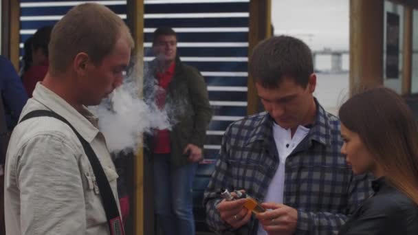 СЕНТ-ПЕТЕРБУРГ, РОССИЯ - 28 мая 2016 года: Мужчины курят электронные сигареты на улице. Справедливо. Вэйперс. Курение. Пар . — стоковое видео
