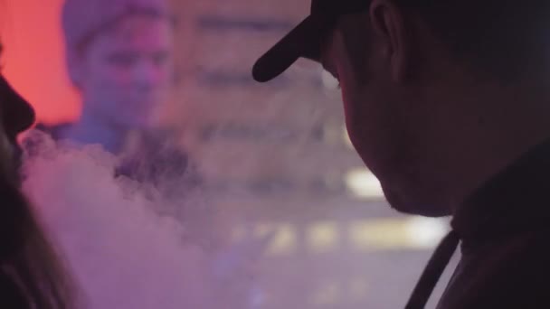 САЙНТ-ПЕТЕРБУРГ, РОССИЯ - 28 мая 2016 года: Силуэтные испарители курят электронные сигареты в ночном клубе. Прожекторы. Фестиваль — стоковое видео