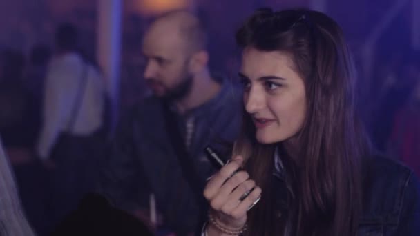 САЙНТ-ПЕТЕРБУРГ, РОССИЯ - 28 мая 2016 года: Девушка курит электронную сигарету в ночном клубе. Прожекторы. Фестиваль испарений — стоковое видео