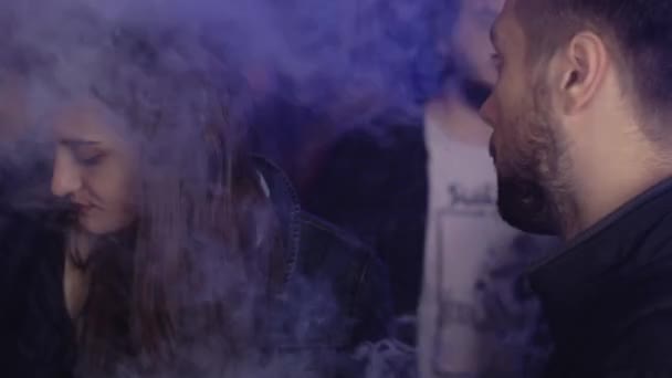 SAN PETERSBURG, RUSIA - 28 DE MAYO DE 2016: El hombre fuma cigarrillo electrónico en el club nocturno. Foco. Festival de pañales. Chica. — Vídeo de stock