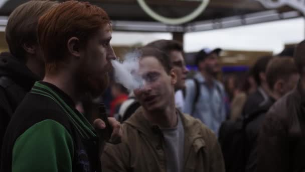 SAINT PETERSBURG, RUSSIA - 28 MAGGIO 2016: Uomo barbuto fuma sigaretta elettronica in strada tra la gente. Festival dei Vapers . — Video Stock