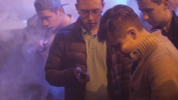 圣彼得堡，俄罗斯-2016 年 5 月 28 日 ︰ 男子吸烟电子烟在专门店。云顶。射灯。蒸汽 — 图库视频影像