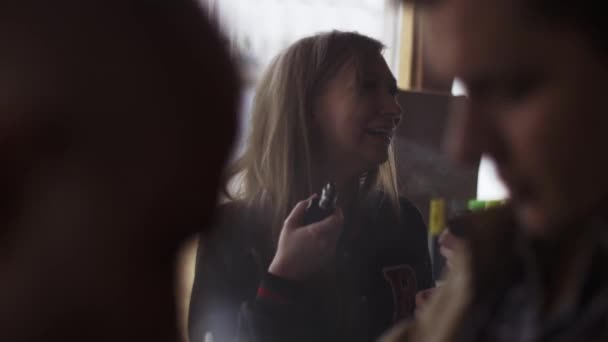 САЙНТ-ПЕТЕРБУРГ, РОССИЯ - 28 мая 2016 года: Блондинка курит электронные сигареты в специализированном магазине на улице. Пар — стоковое видео