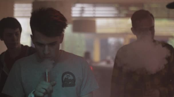 St. petersburg, russland - 28. Mai 2016: Junger Mann atmet im Fachgeschäft Dampf aus elektronischer Zigarette aus. Verdampfer — Stockvideo