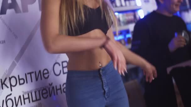 SAINT PETERSBURG, RÚSSIA - 28 de maio de 2016: Slim go girl in blue jeans black top dance at stand in nightclub. Destaques . — Vídeo de Stock