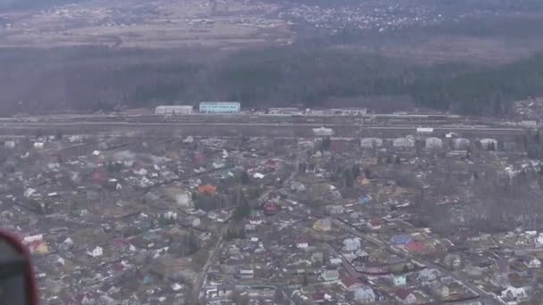 Вид с борта вертолета. Камера внутри. Пейзаж сельской местности. Много зданий. Лес — стоковое видео