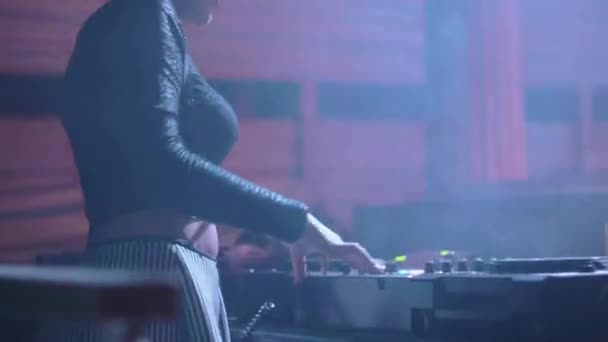 Parte de trás da menina Dj em preto top girando e misturando na plataforma giratória na boate . — Vídeo de Stock