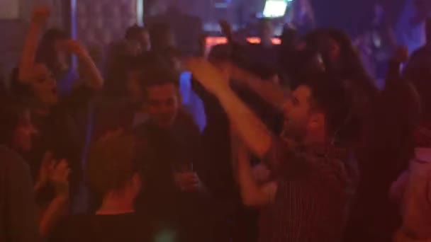 SAN PETERSBURG, RUSIA - 13 DE FEBRERO DE 2016: La gente baila en una discoteca abarrotada. Levanta las manos. Iluminaciones. Juventud — Vídeo de stock