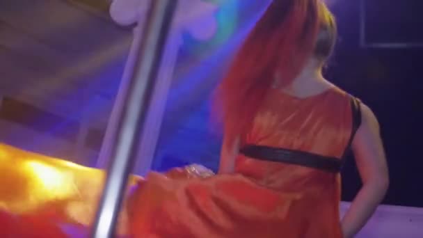Petrohrad, Rusko - 13 února 2016: Sexy jít jít tanečnice s červeným pelerína otáčet na pólu v nočním klubu. Zpomalený pohyb — Stock video
