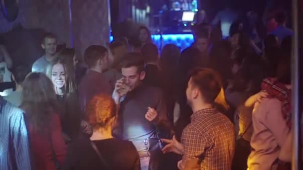 SAN PETERSBURG, RUSIA - 13 DE FEBRERO DE 2016: La gente baila en una discoteca abarrotada. Niño con bebida en la bolsa. Movimiento lento — Vídeos de Stock