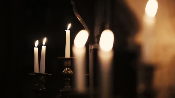 Velas blancas encendidas en candelabros. Fuego. Llama. — Vídeos de Stock