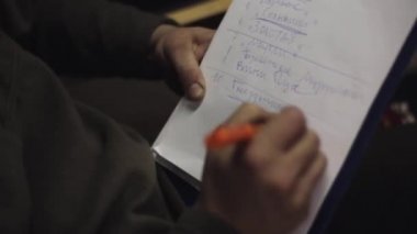 Adam altı çizili kelime listesinde kalem yanında ağıl içinde kağıt üstünde. Keneler yazmak.