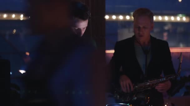 DJ spinnen bij draaitafel op party in discotheek. Man met saxofoon. Juichen. — Stockvideo