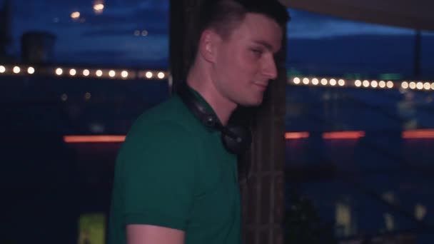 Porträt eines DJs, der sich am Plattenteller in einem Nachtclub dreht und mischt. Blick in die Kamera — Stockvideo