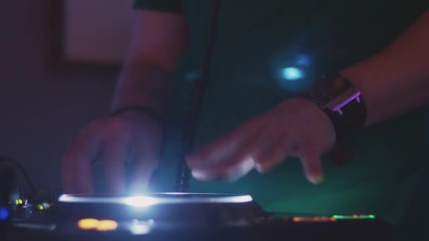 DJ spinning på upplysta skivspelare på fest i nattklubben. Utrustning. Hörlurar — Stockvideo