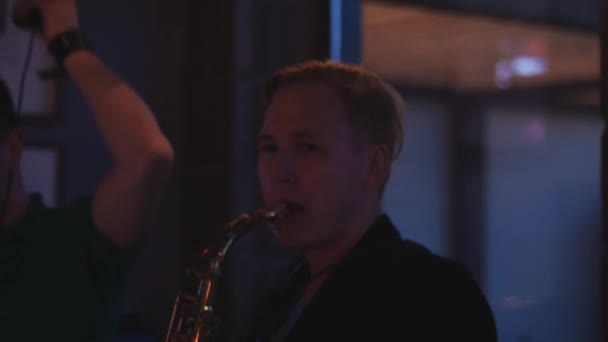Man spelen saxofoon op party in discotheek. Prestaties. Vakantie. Juichen. — Stockvideo