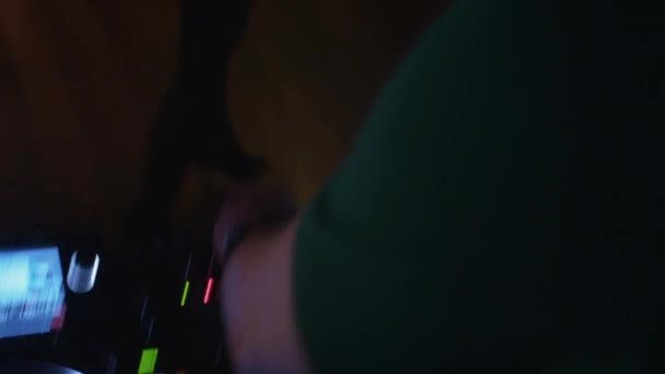 DJ točí na gramofonu na párty v nočním klubu. Míchání. Sluchátka. Lidé. — Stock video