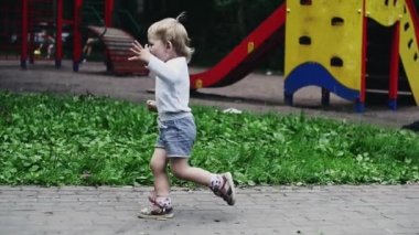 Şortluk küçük çocuk güvercinlere koşuyor. Kuşlar uçup gider. Yaz parkı. Mutluluk.