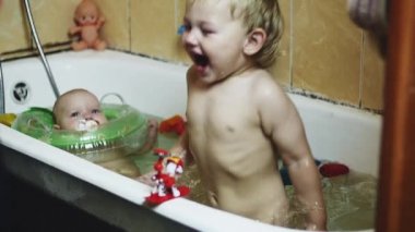 Küçük çocuk küvete su sıçratSın. Bebek şişme daire içinde yüzmek. Mutluluk.