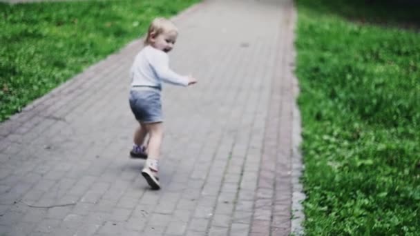 Niño rubio corriendo en el parque infantil en el parque de verano. Infancia. Felicidad — Vídeos de Stock