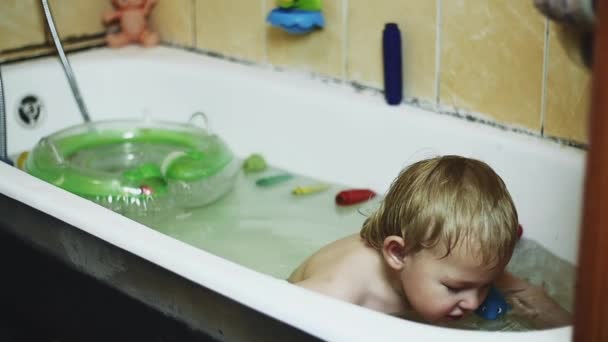 Little boy enjoy water in bathtub. Inflatable circle. Happy. Playing with toys — Stock Video