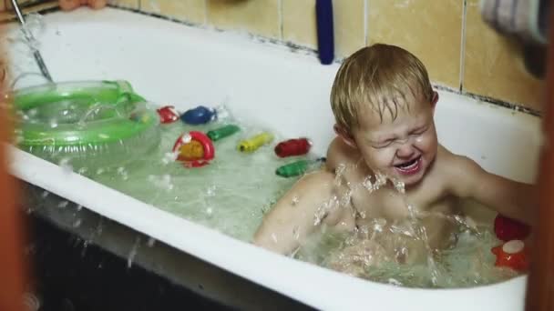 Little boy splash water in bathtub by feet. Inflatable circle. Happy. Bathing. — Stock Video